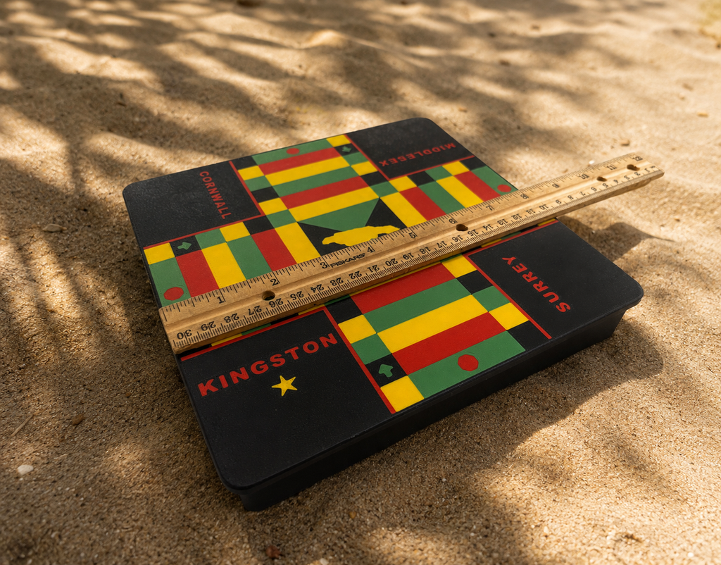 Colorful Kingston Surrey Cornwall middlesex 3d printed lock pon stop ludi board with Jamaican counties on sand with a ruler for scale