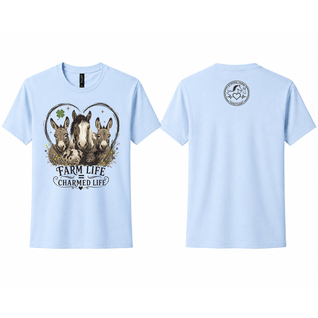 Light blue Next Level 6410 sueded t-shirt shown from the front and back. The front features a vintage-style "Farm Life Charmed Life" graphic with rescued donkeys, a horse, heart outline, clover, and wildflowers. The back includes the Strong Farm Sanctuary logo printed below the collar.