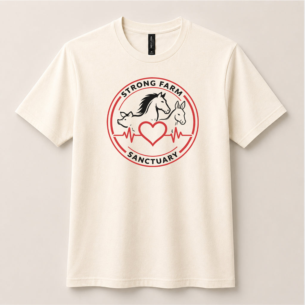 Natural Next Level 6410 sueded t-shirt featuring the official Strong Farm Sanctuary logo printed on the front chest. The circular logo includes a horse, donkey, pig, heart, and heartbeat line representing the sanctuary's mission to rescue and care for farm animals.